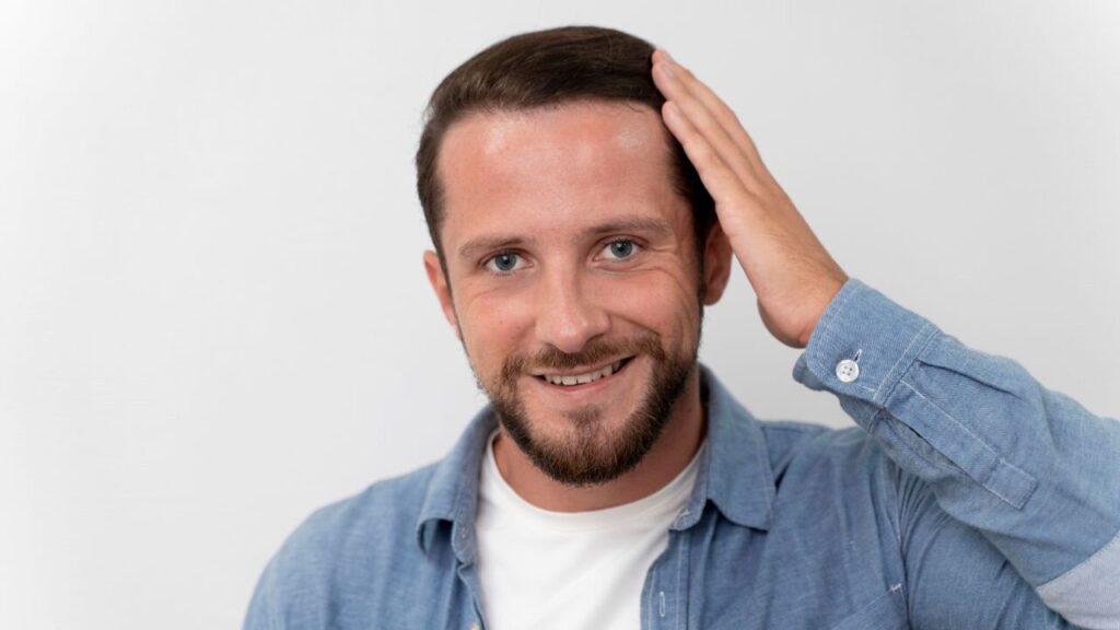 A man touches his hair, wondering: What is a toupee?
